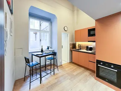 a kitchen with a table and chairs in a room at New Modern Art Loft Apartment, City Center in Prague
