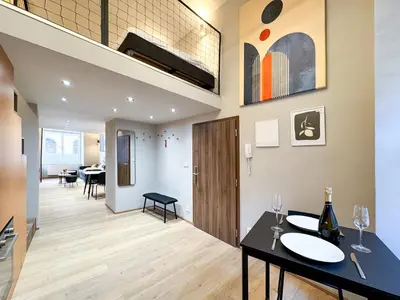a living room with a table and a dining room at New Modern Art Loft Apartment, City Center in Prague