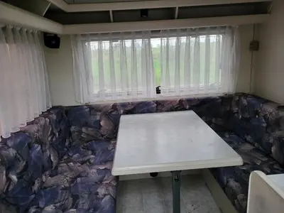 a couch with a table in front of a window at Kempování s výhledem na hrady in Zdice