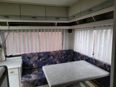 a living room with a couch in front of two windows at Kempování s výhledem na hrady in Zdice