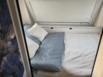 a bed in a small room with a window at Kempování s výhledem na hrady in Zdice
