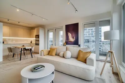 a living room with a couch and a table at Chloé's Beige Apartment with big balcony, O2 arena in Prague