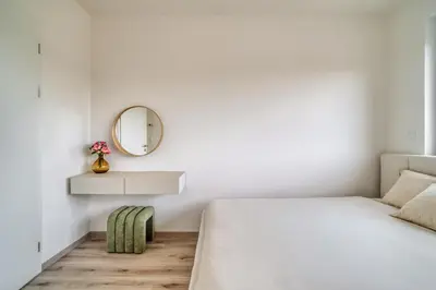 a white bedroom with a bed and a mirror at Chloé's Beige Apartment with big balcony, O2 arena in Prague