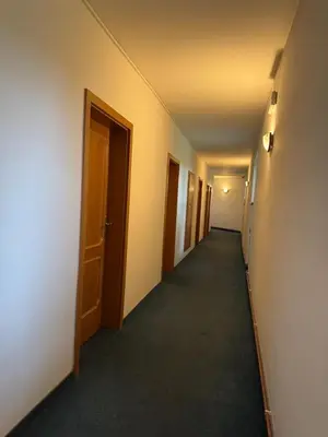 a hallway of an empty room with two doors at Park Pension