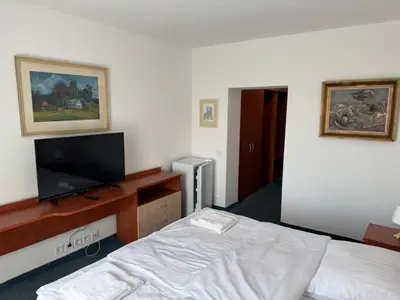 a bedroom with a bed and a flat screen tv at Park Pension