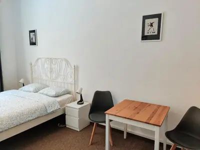 a bedroom with a bed and two chairs and a table at Comfy 2 Bedrooms Flat 4 persons & Parking in Prague