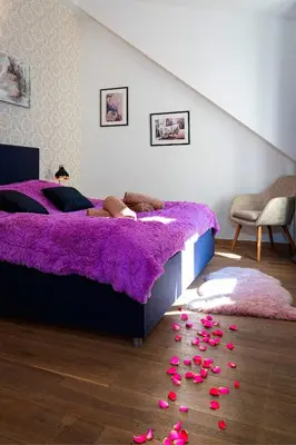 a bedroom with a purple bed with roses on the floor at Brilliant Rabbit Residence in Prague