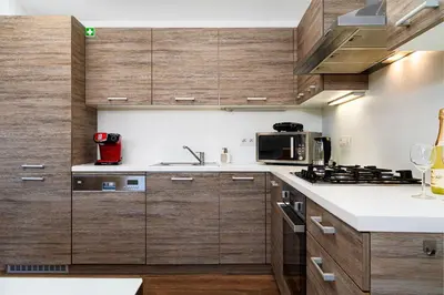 a kitchen with wooden cabinets and a microwave at Brilliant Rabbit Residence in Prague