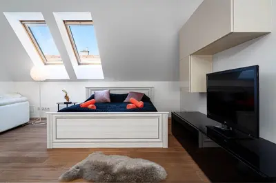 a living room with a bed and a flat screen tv at Brilliant Rabbit Residence in Prague