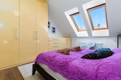 a bedroom with a purple bed with a teddy bear on it at Brilliant Rabbit Residence in Prague