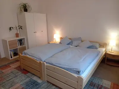a bedroom with a bed with blue sheets and two lamps at Apartmán Na Leštině in Příbram