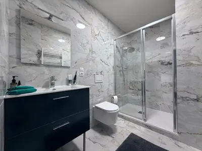 a bathroom with a shower and a toilet and a sink at Mulino Apartments