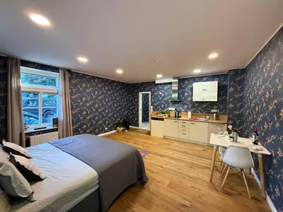 a bedroom with a bed and a table and a kitchen at Mulino Apartments