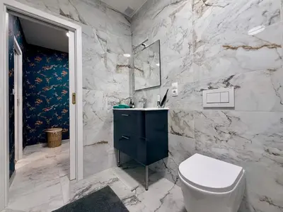 a bathroom with a white toilet and a sink at Mulino Apartments