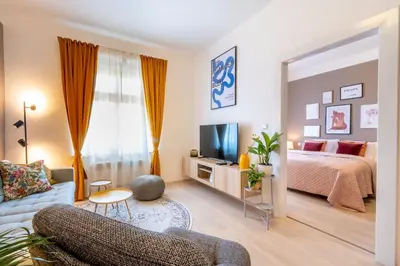a bedroom with a bed and a couch and a television at Cozy Apartment near The Old Town Square in Prague