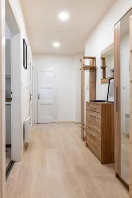 an empty room with white walls and wooden floors and a kitchen at Cozy Apartment near The Old Town Square in Prague