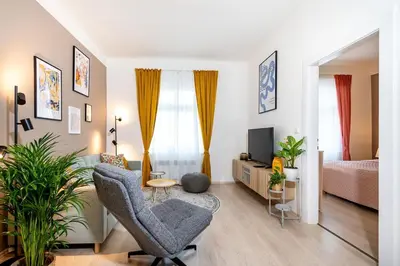 a living room with a couch and a chair and a television at Cozy Apartment near The Old Town Square in Prague