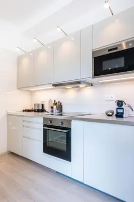 a kitchen with white cabinets and a stove top oven at Cozy Apartment near The Old Town Square in Prague