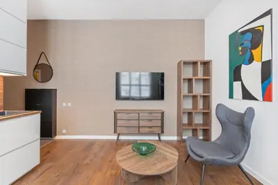 a living room with a table and a chair and a television at Design Apartment in the heart of Old Town Prague in Prague