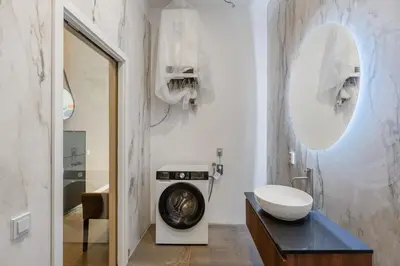 a bathroom with a washing machine and a sink at Design Apartment in the heart of Old Town Prague in Prague