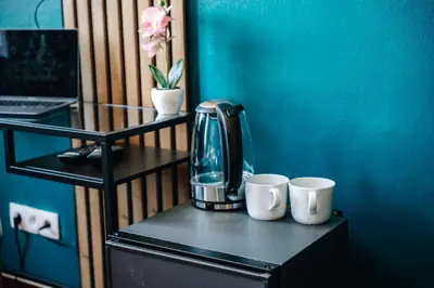 a coffee maker on a table with two cups at Smichov MixHause Residence by Wagnerstays in Prague