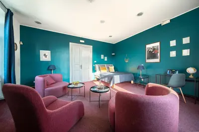 a bedroom with blue walls and pink chairs and a bed at Smichov MixHause Residence by Wagnerstays in Prague