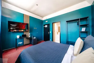 a blue bedroom with a bed and a flat screen tv at Smichov MixHause Residence by Wagnerstays in Prague