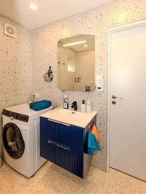 a bathroom with a washing machine and a sink at Apartment Hanspaulka - Stylish, Parking Included, 15 min Airport in Prague