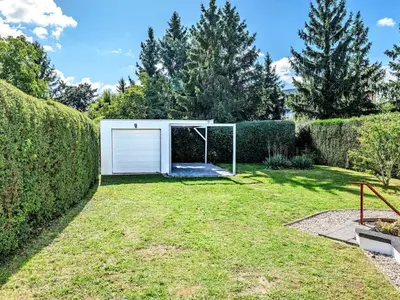 a backyard with a garage and a lawn at Apartment Hanspaulka - Stylish, Parking Included, 15 min Airport in Prague