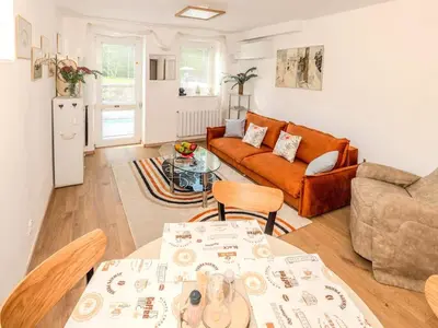 a living room with a couch and a table at Apartment Hanspaulka - Stylish, Parking Included, 15 min Airport in Prague