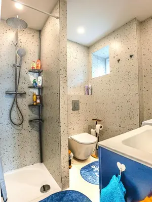 a bathroom with a shower and a toilet and a tub at Apartment Hanspaulka - Stylish, Parking Included, 15 min Airport in Prague