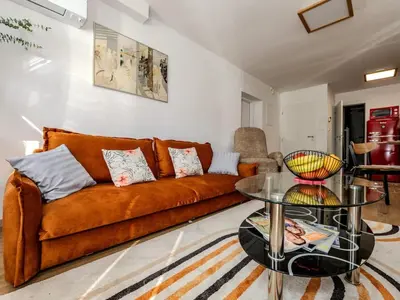 a living room with a couch and a glass table at Apartment Hanspaulka - Stylish, Parking Included, 15 min Airport in Prague