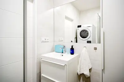 a white bathroom with a sink and a microwave at Prague Days - Studio near Vyšehrad with Netflix and 250Mbs WiFi in Nusle in Prague