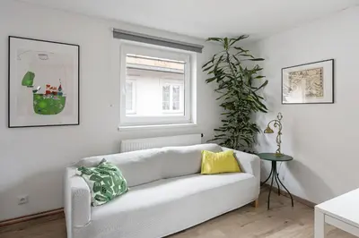 a kitchen with a white table and chairs and a window at Sunny studio Prague in Prague