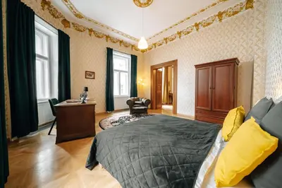 a bedroom with a bed and a desk and windows at Bohemia Grand Residence by Wagnerstays in Prague