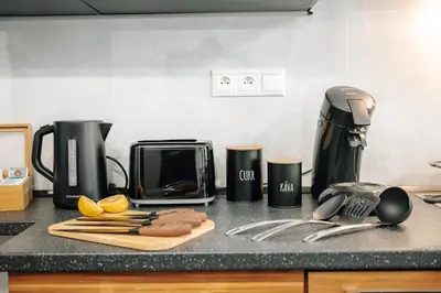 a kitchen counter with a coffee maker and utensils at Bohemia Grand Residence by Wagnerstays in Prague