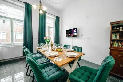 a dining room with a table and green chairs at Bohemia Grand Residence by Wagnerstays in Prague