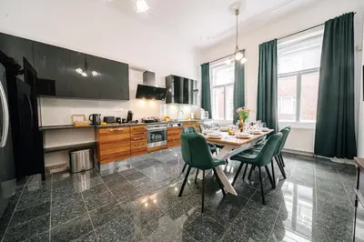 a kitchen with a dining table and green chairs at Bohemia Grand Residence by Wagnerstays in Prague