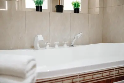 a bathroom with a white sink and a tub at Bohemia Grand Residence by Wagnerstays in Prague