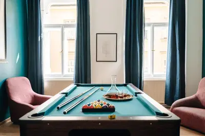 a pool table in a room with two chairs at Bohemia Grand Residence by Wagnerstays in Prague
