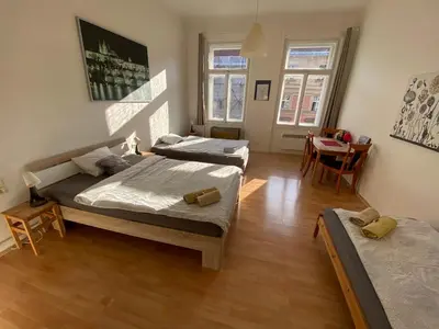 a bedroom with two beds and a table and chairs at Johan apartments in old Vinohrady in Prague