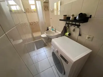 a bathroom with a washing machine and a sink at Johan apartments in old Vinohrady in Prague