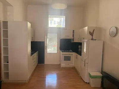 a kitchen with white cabinets and a refrigerator at Johan apartments in old Vinohrady in Prague
