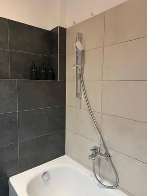 a bath tub with a shower head in a bathroom at Apartmán U Smaltovny 27 in Prague