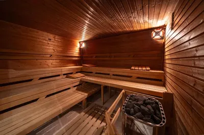 an empty wooden sauna with a bench in it at Party ClubHouse with Bar, Panoramic Pool & Sauna in Prague