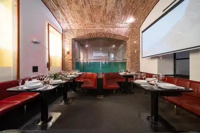a dining room with tables and red chairs and a large screen at Party ClubHouse with Bar, Panoramic Pool & Sauna in Prague