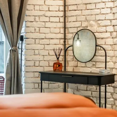 a black table with a mirror on a brick wall at Dream Luxury Studio Prague DS1 in Prague