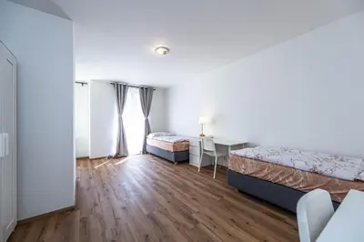 a bedroom with two beds and a desk and a table at Apartments Rehorova 30 in Prague