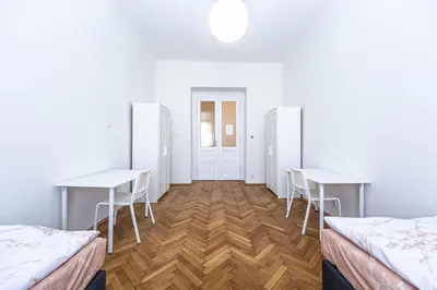 a room with two beds and two tables and chairs at Apartments Rehorova 30 in Prague