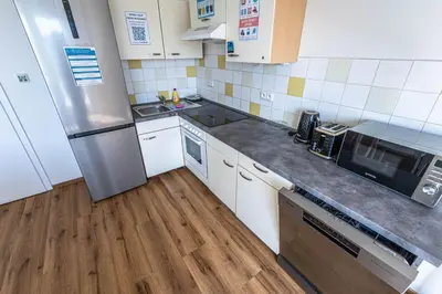 a kitchen with white cabinets and a stainless steel refrigerator at Apartments Rehorova 30 in Prague